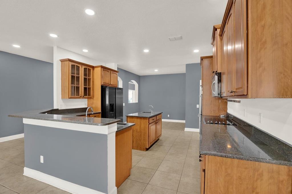 13397 Hunters Point Street Spring Hill, FL 34609 - Photo 8 of 38 a kitchen with stainless steel appliances granite countertop a sink a stove and a refrigerator