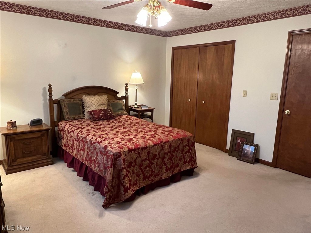 36555 Flat Rock Road Barnesville, OH 43713 - Photo 12 of 35 Carpeted bedroom featuring ceiling fan, a closet, and a textured ceiling