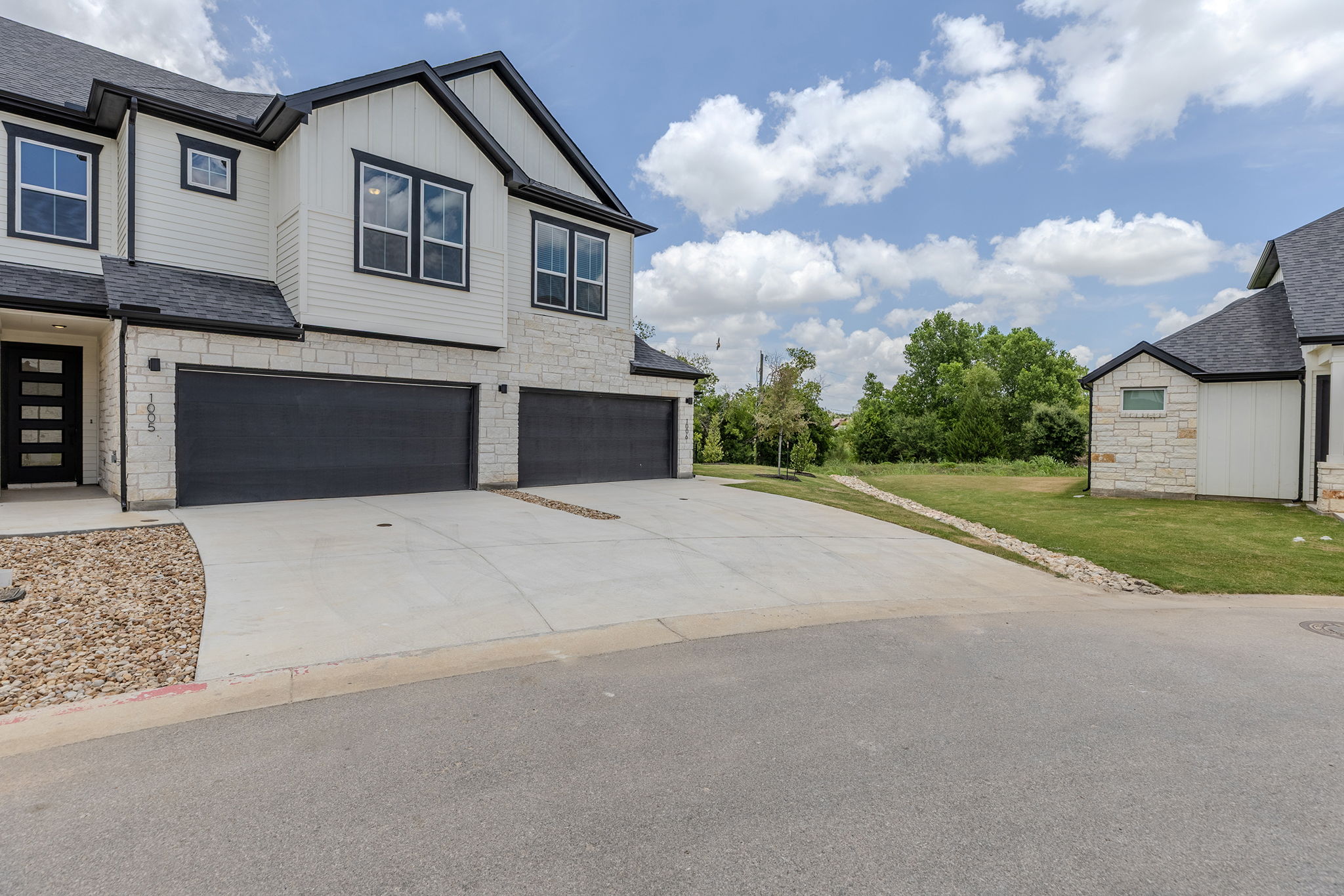 2600 Gattis School Road, Unit 1004 Round Rock, TX 78664 - Photo 38 of 40 A contemporary duplex with strong curb appeal features a black and white exterior with stone accents and dual garage access.