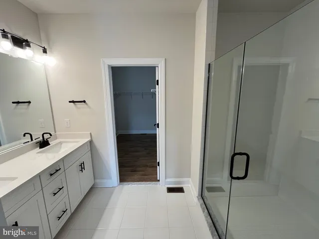 a bathroom with a granite countertop toilet a sink and shower