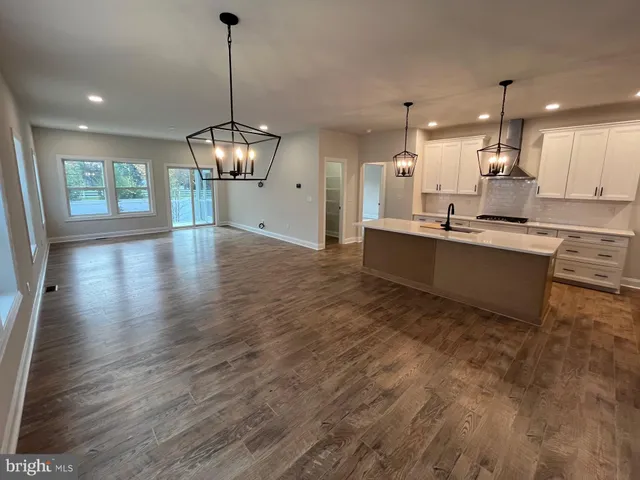 a kitchen with stainless steel appliances granite countertop wooden floors sink and cabinets