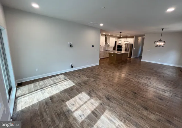 a view of a living room with kitchen furniture and wooden floor