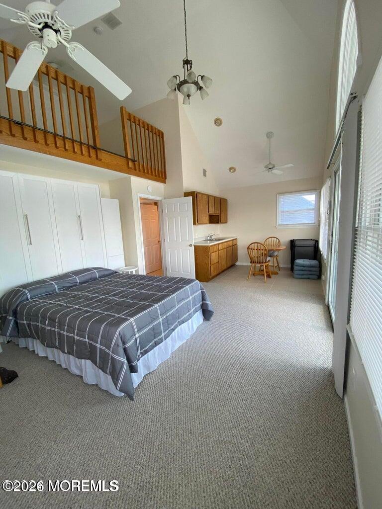 564 Perch Avenue Manasquan, NJ 08736 - Photo 13 of 15 a spacious bedroom with a bed and a chandelier