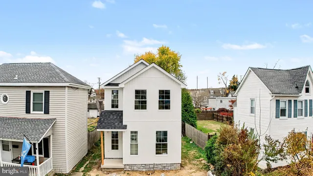 a view of a white house with large windows and a small yard