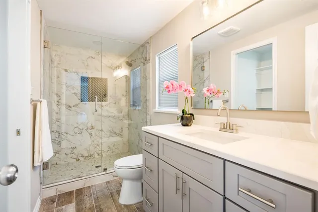 a bathroom with a sink vanity mirror and toilet