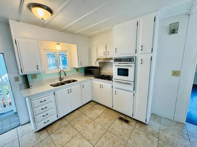 a kitchen with cabinets appliances and a window