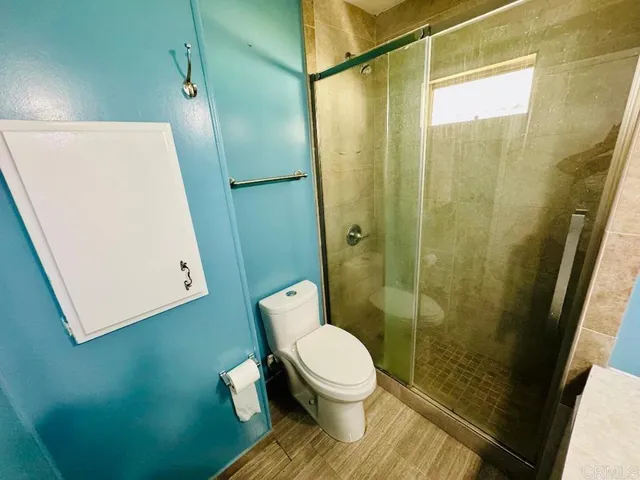 a bathroom with a toilet and a shower