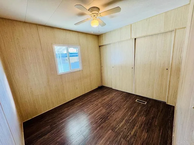 a view of an empty room and window with wooden floor