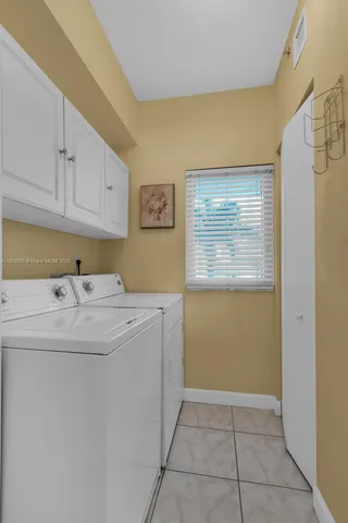 a utility room with cabinets washer and dryer