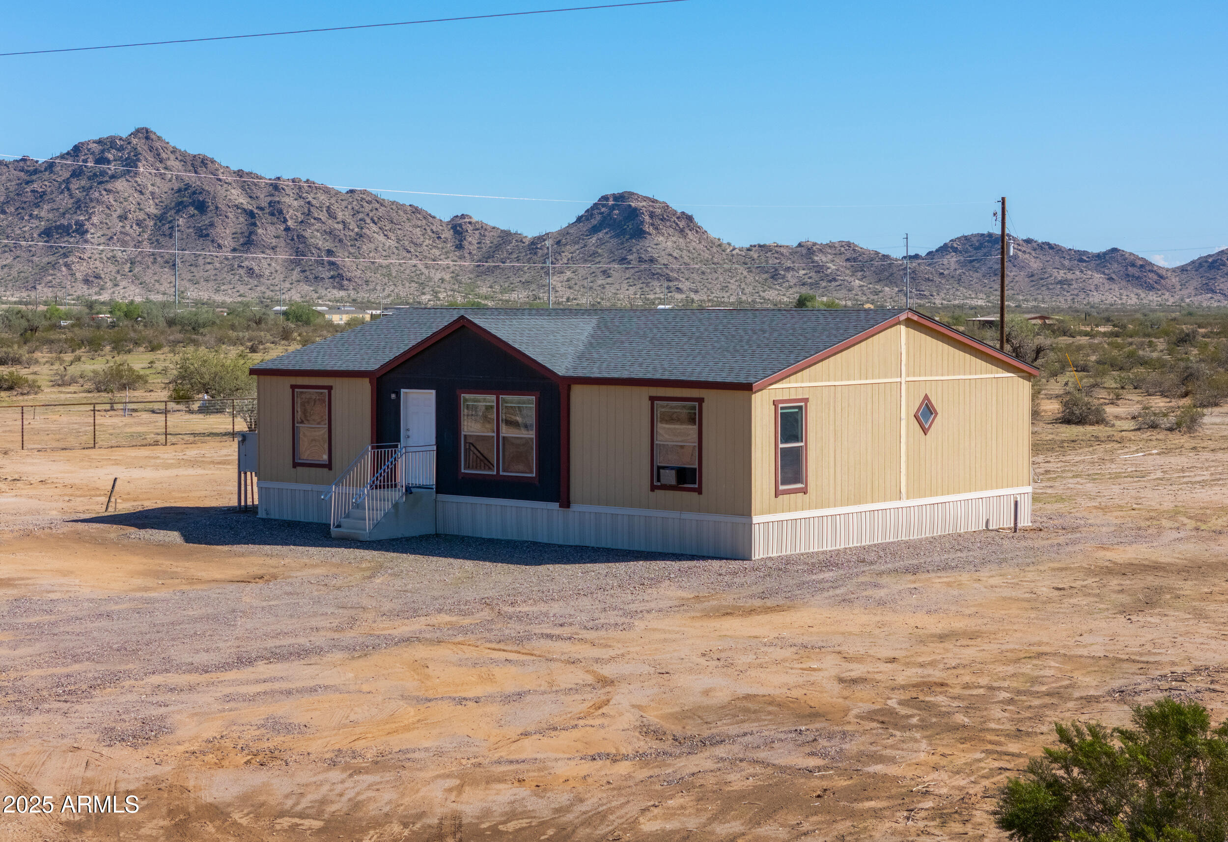 a front view of a house with a yard and mountain view in back