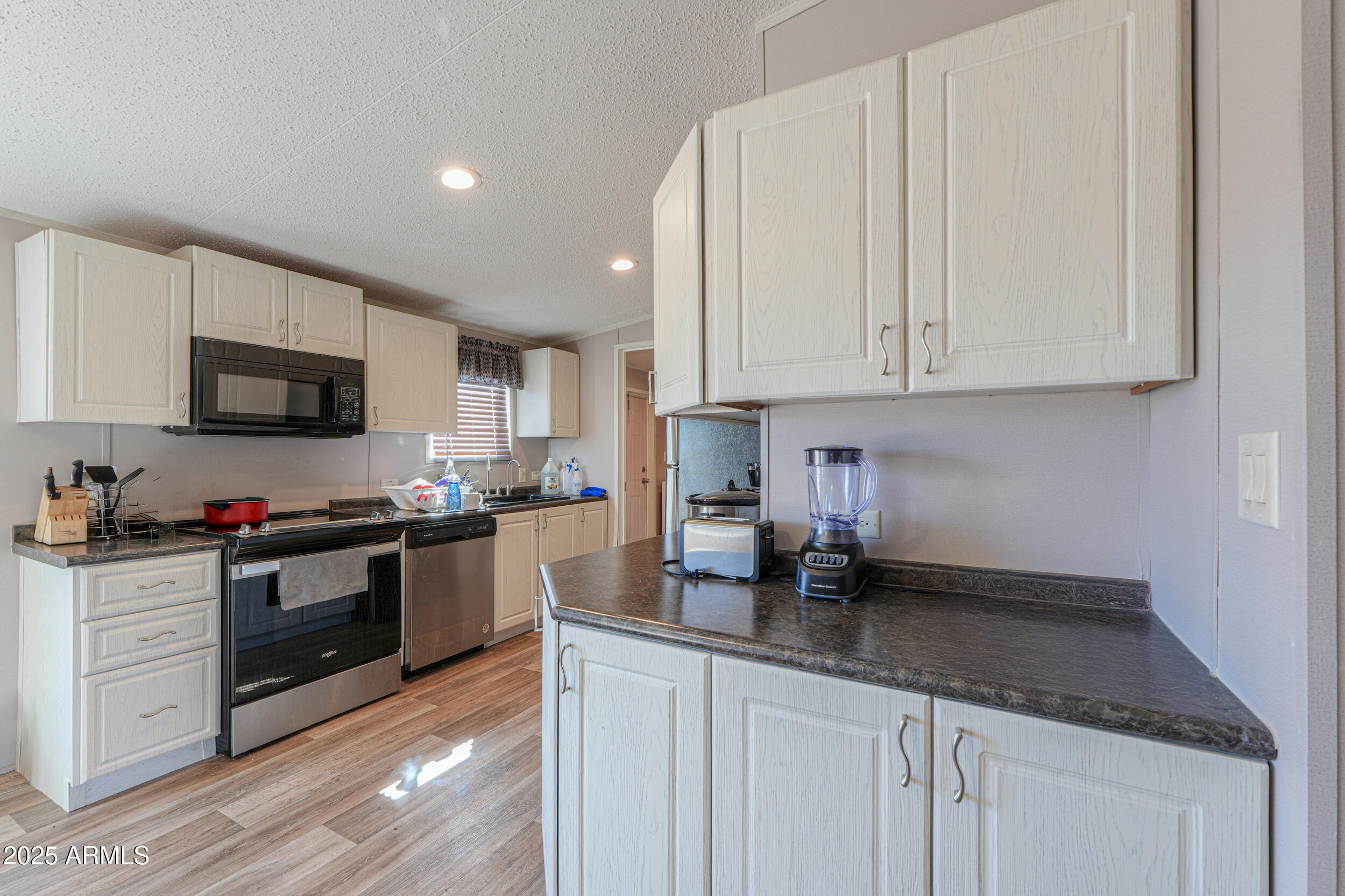 11091 North Garduno Road Maricopa, AZ 85139 - Photo 11 of 51 a kitchen with granite countertop white cabinets and stainless steel appliances