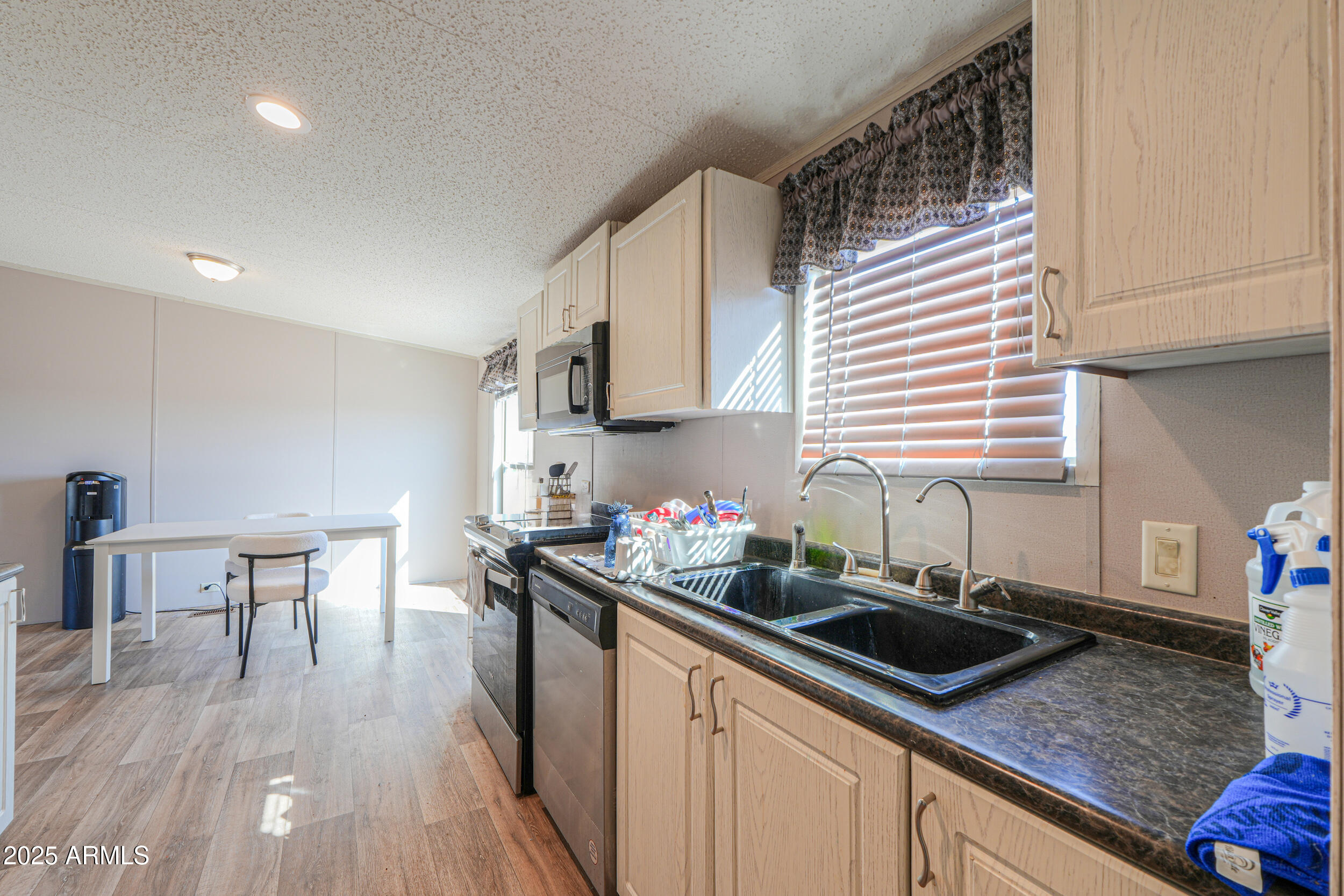 11091 North Garduno Road Maricopa, AZ 85139 - Photo 13 of 51 a kitchen with a sink a stove a microwave cabinets and wooden floor