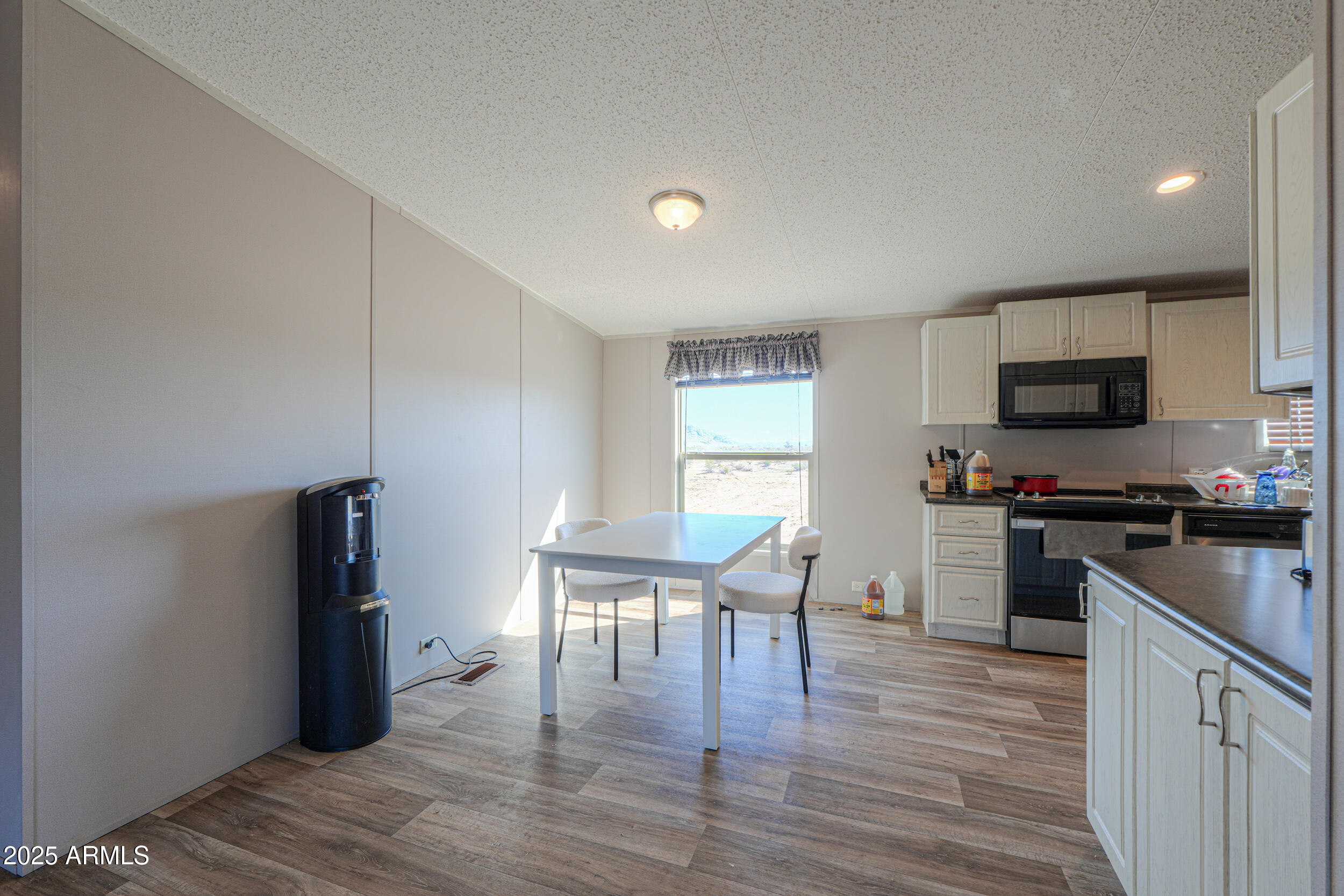 11091 North Garduno Road Maricopa, AZ 85139 - Photo 8 of 51 a kitchen with a table chairs microwave and refrigerator