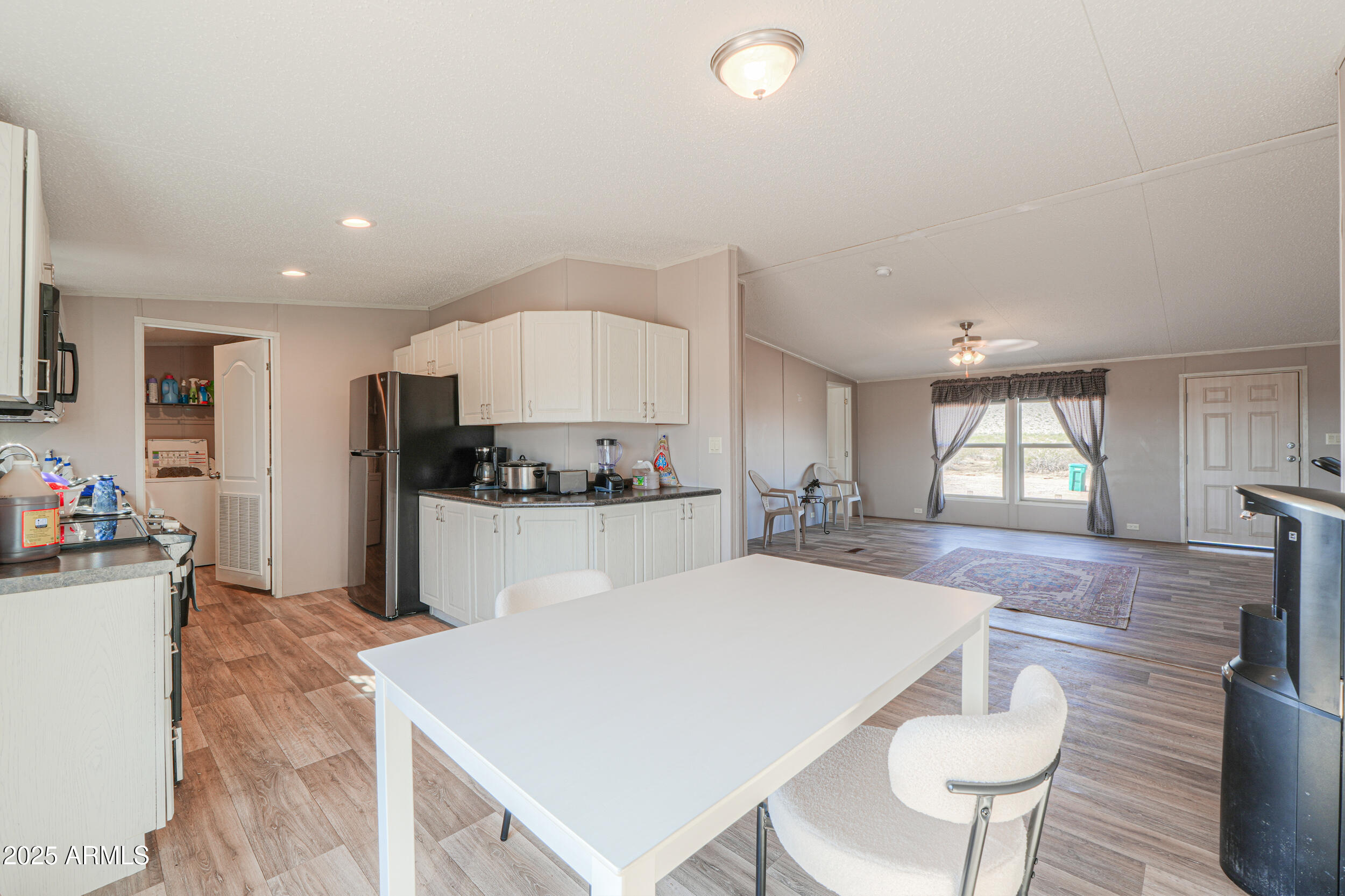 11091 North Garduno Road Maricopa, AZ 85139 - Photo 9 of 51 a kitchen with kitchen island a stove a table and chairs in it