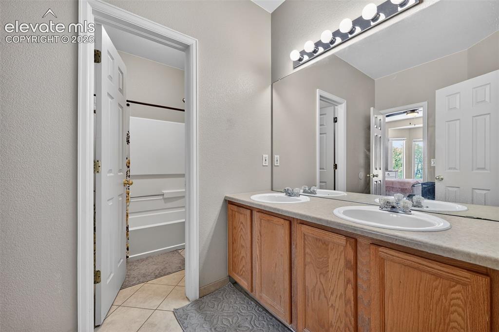 2141 Legacy Ridge View, Unit 109 Colorado Springs, CO 80910 - Photo 13 of 23 a bathroom with a double vanity sink and mirror