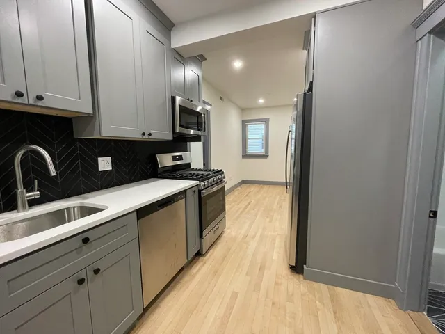 a kitchen with a sink a stove and cabinets