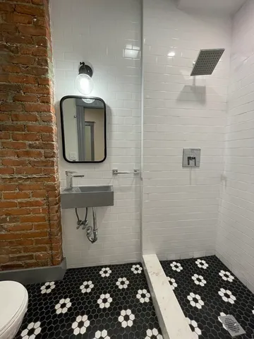 a bathroom with a sink a toilet and mirror