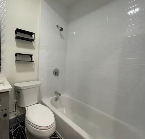 a white toilet sitting next to a bath tub