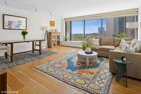 a living room with furniture a rug and a dining table