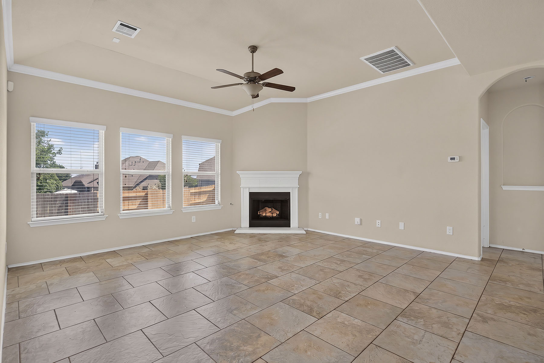 4601 Chestnut Meadows Bend Georgetown, TX 78626 - Photo 11 of 35 A corner fireplace and multiple windows illuminate this spacious living area with durable tiled flooring.