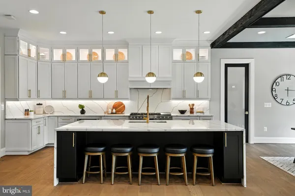 a kitchen with stainless steel appliances granite countertop a sink a stove a refrigerator and island with wooden floor