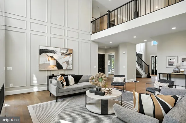a living room with furniture a table and potted plants with wooden floor