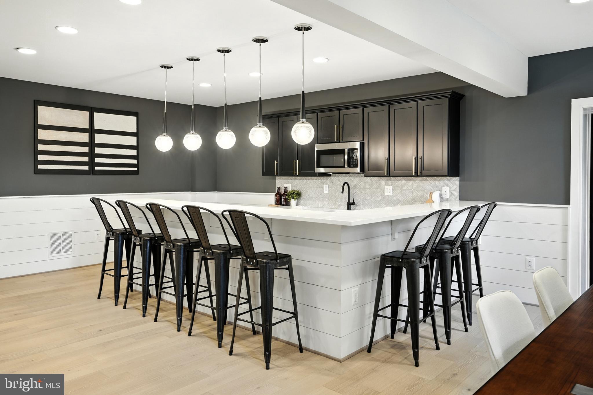 1321 Hunter Mill Road Vienna, VA 22182 - Photo 70 of 92 a kitchen with a dining table chairs and white cabinets
