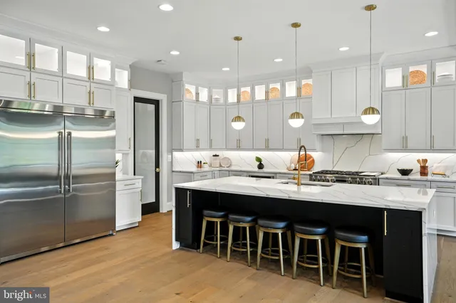 a kitchen with a sink stainless steel appliances and white cabinets