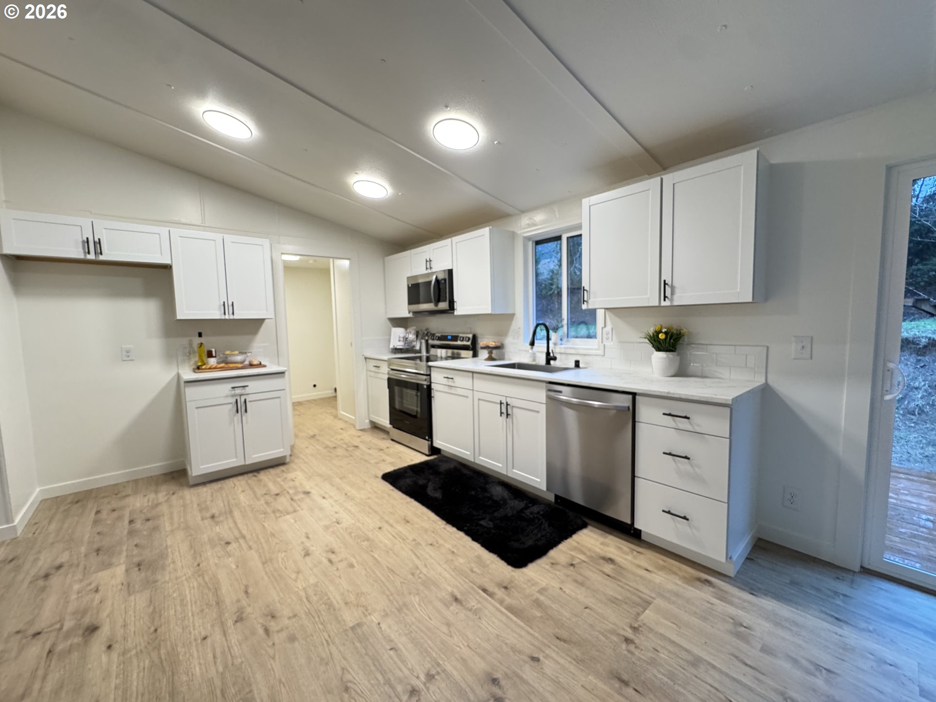 8138 Lewis River Road Ariel, WA 98603 - Photo 16 of 24 a kitchen with white cabinets stainless steel appliances and sink