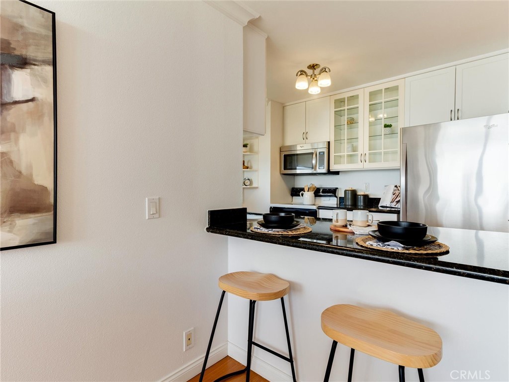 1750 East Ocean Boulevard, Unit 213 Long Beach, CA 90802 - Photo 15 of 52 a kitchen with stainless steel appliances granite countertop a sink a stove a refrigerator a counter top space and cabinets