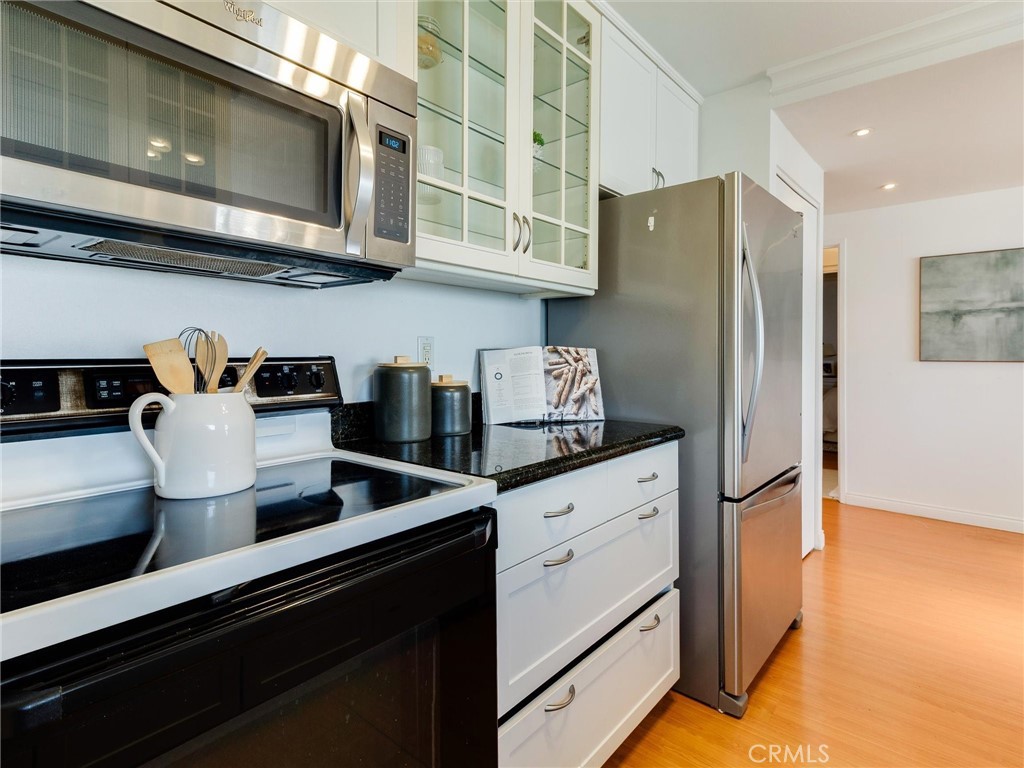 1750 East Ocean Boulevard, Unit 213 Long Beach, CA 90802 - Photo 17 of 52 a kitchen with stainless steel appliances granite countertop a refrigerator and a stove
