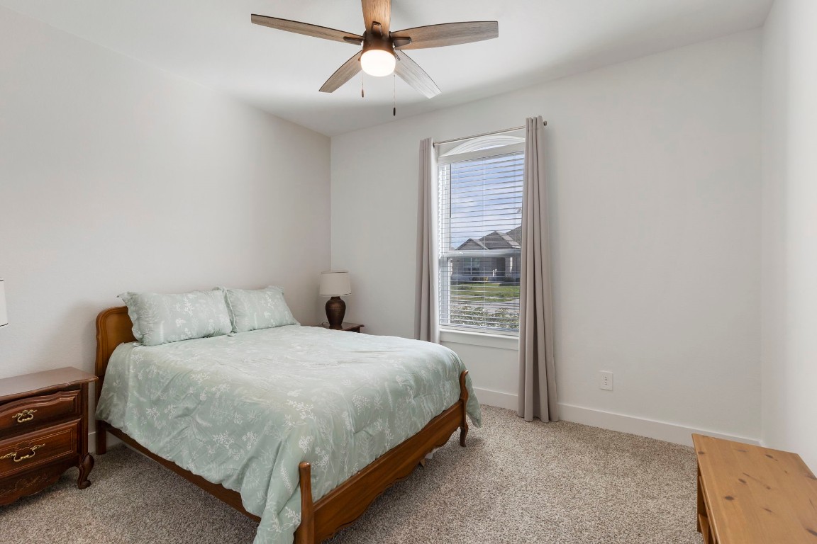13757 Rising Sun Lane Conroe, TX 77384 - Photo 22 of 39 a bedroom with a bed and a chandelier