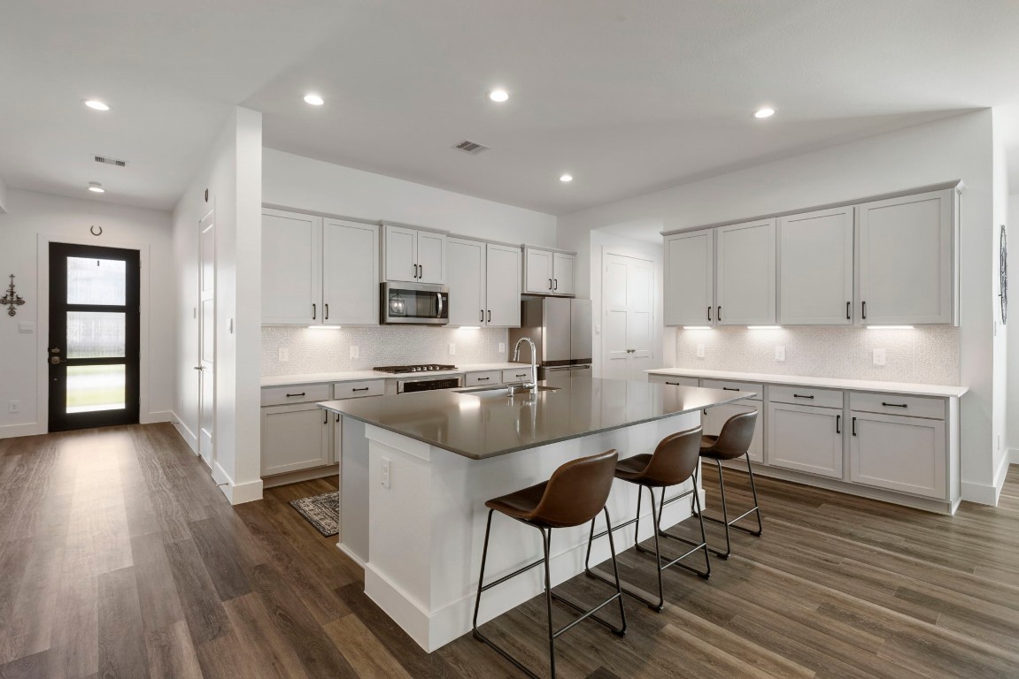 13757 Rising Sun Lane Conroe, TX 77384 - Photo 5 of 39 a kitchen with stainless steel appliances granite countertop a sink a stove a refrigerator and a microwave