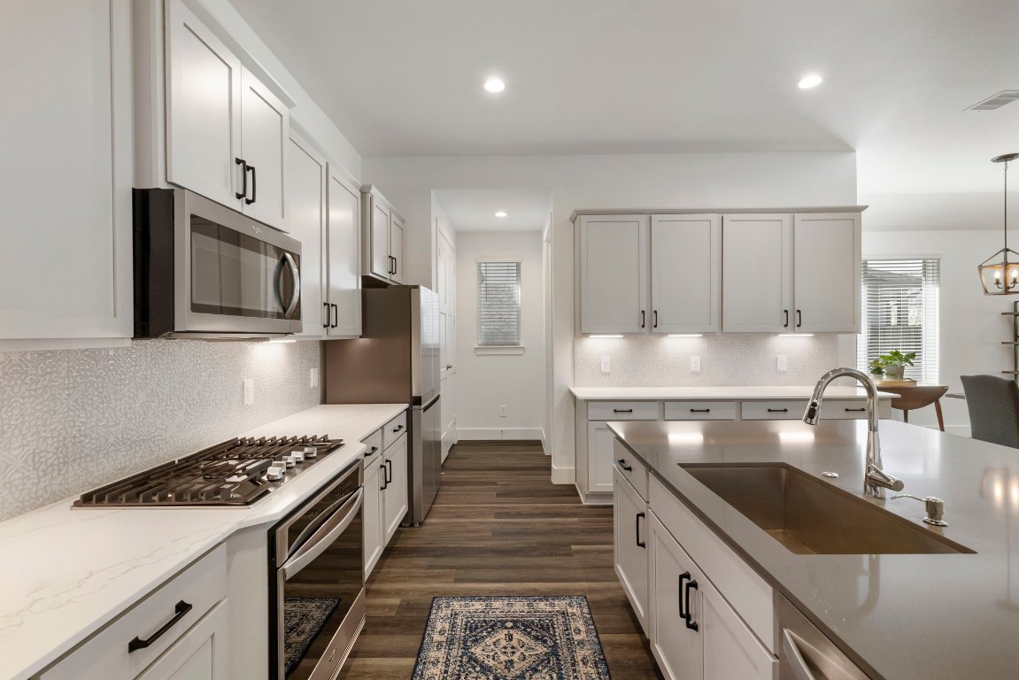 13757 Rising Sun Lane Conroe, TX 77384 - Photo 7 of 39 a kitchen with stainless steel appliances granite countertop a stove a sink and a microwave