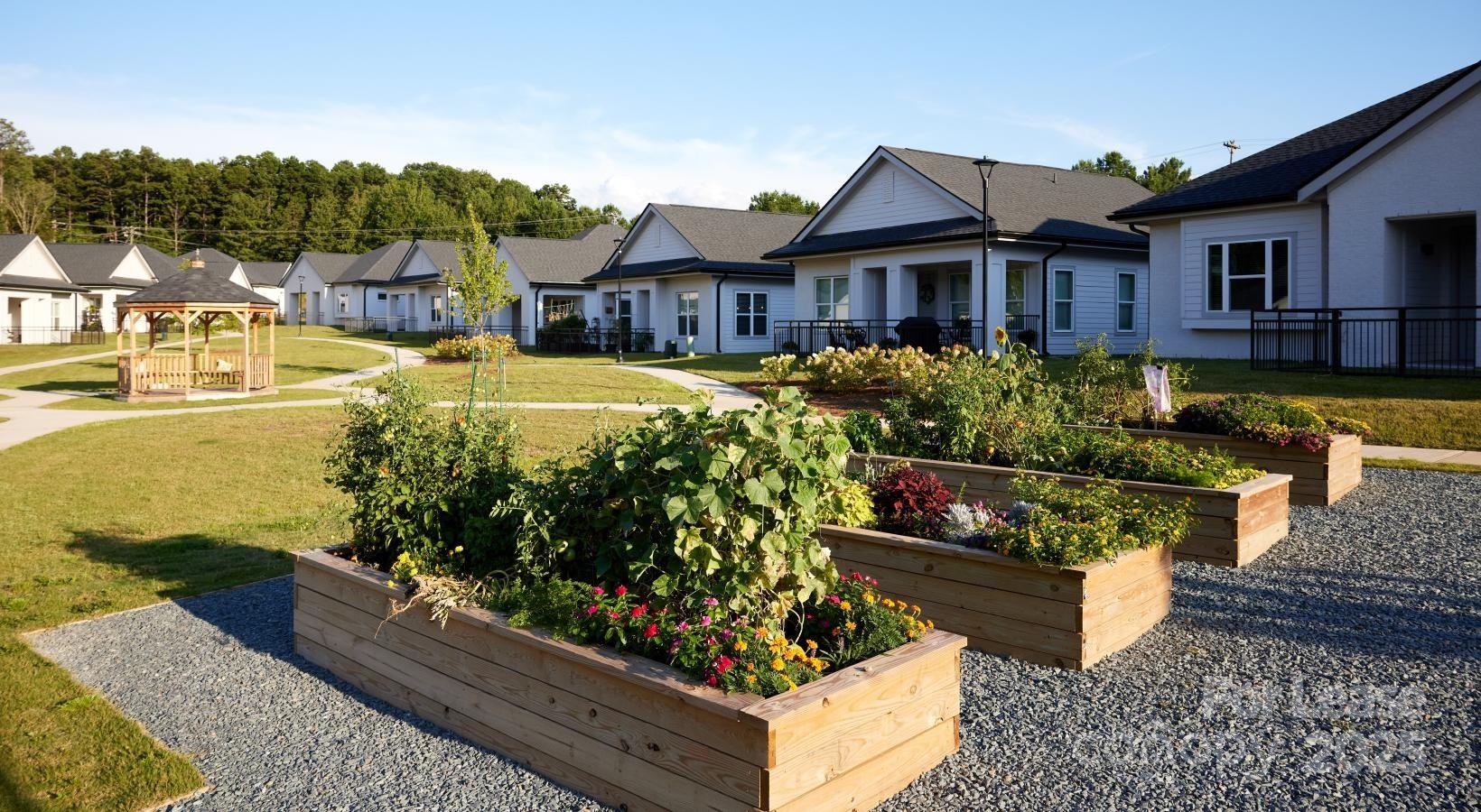4101 Glenloch Circle, Unit A2 Matthews, NC 28105 - Photo 20 of 28 a front view of a house with a yard table and chairs