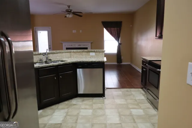 a kitchen with stainless steel appliances granite countertop a stove a sink and a refrigerator