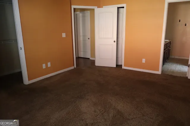 an empty room with closet and windows