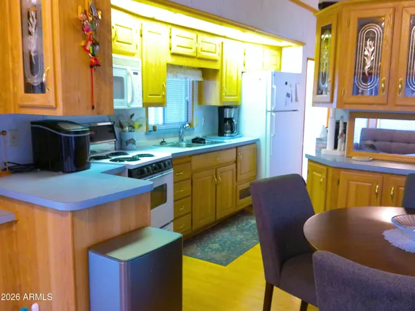a view of a hallway with wooden floor and a bathroom