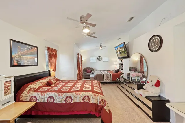 a spacious bedroom with a bed and a chandelier