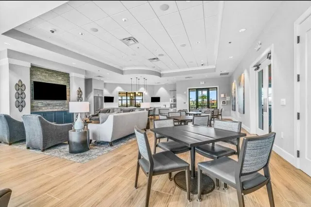 a kitchen with a table chairs refrigerator and microwave