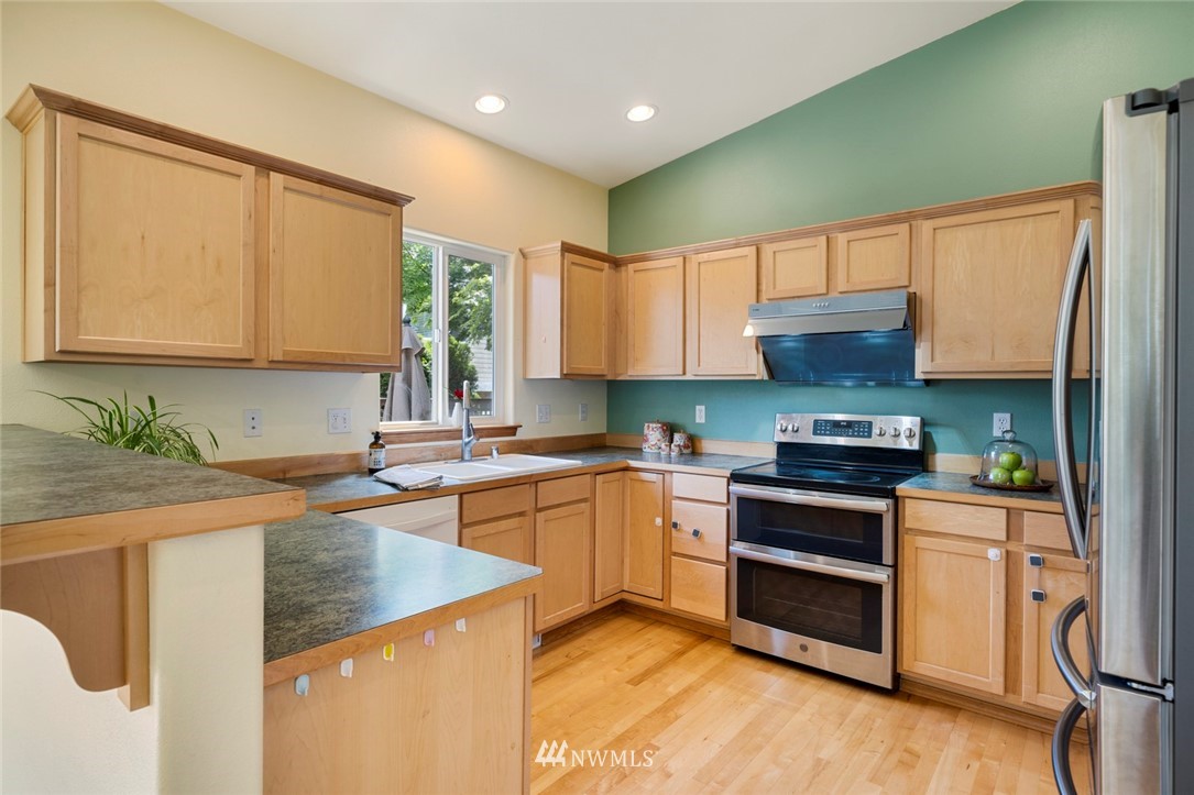 3530 186th Place Southeast Bothell, WA 98012 - Photo 10 of 38 a kitchen with stainless steel appliances granite countertop a sink stove and refrigerator