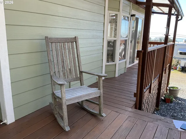 a view of a patio with table and chairs with wooden floor and fence