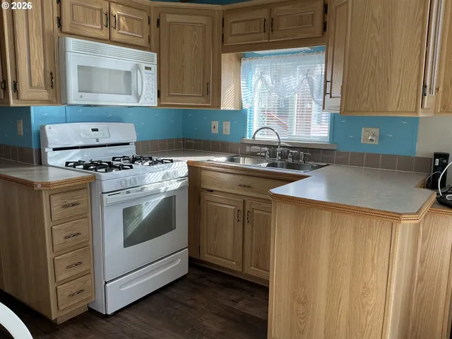 a kitchen with granite countertop a sink stove and cabinets