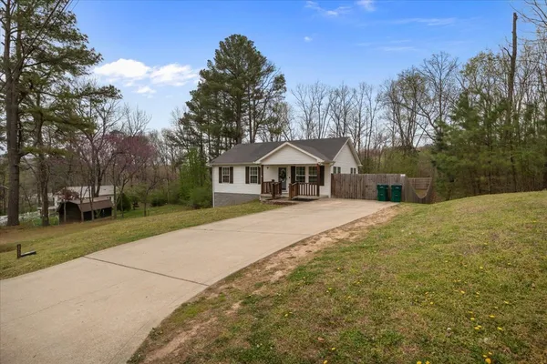 a front view of a house with a yard and trees