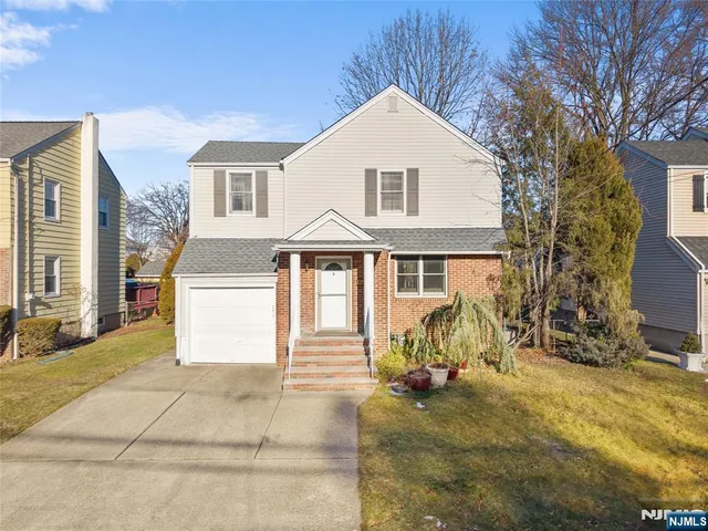 a view of a white house with large windows and a small yard