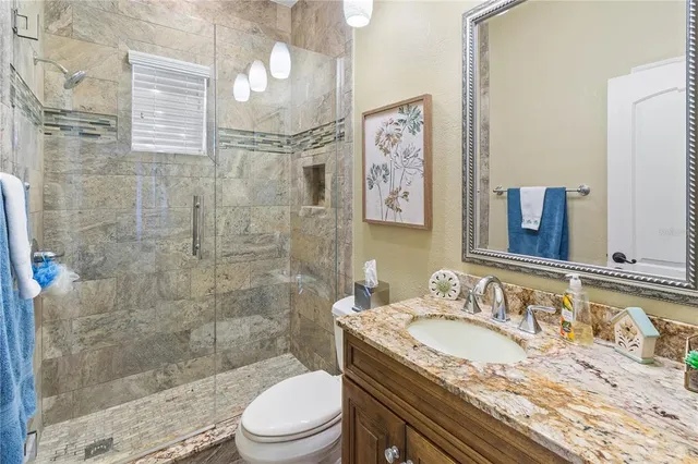 a en suite bathroom with a granite countertop sink and a mirror