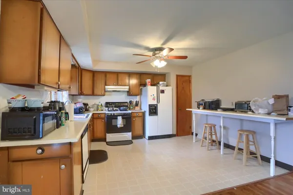 a kitchen with a table chairs refrigerator and cabinets