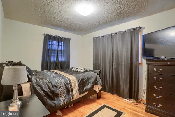 a bedroom with a bed and a lamp with the dresser