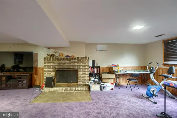 a living room with furniture a fireplace and gym equipment