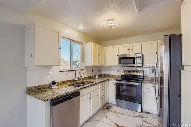 a kitchen with stainless steel appliances a stove sink microwave and cabinets